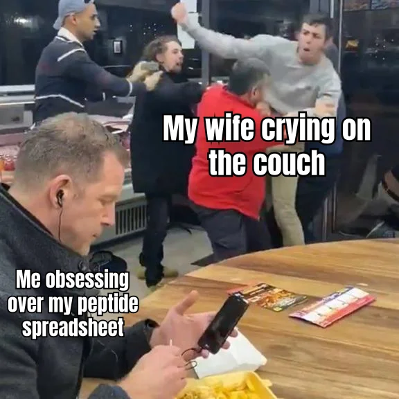 Spreadsheet Over Spouse — The color-coded injection log has achieved higher emotional priority than the woman audibly weeping six feet away.